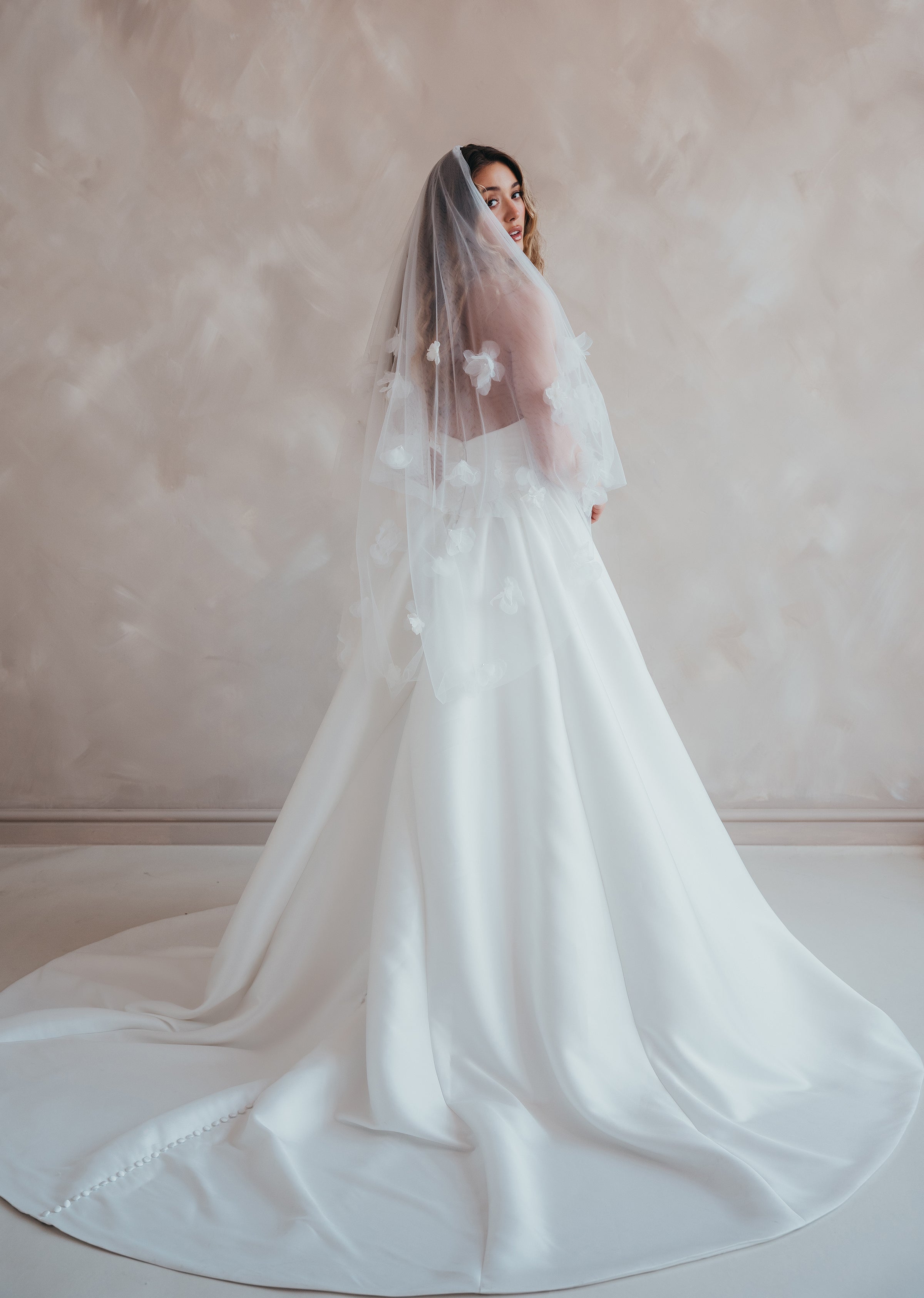 Bride wearing the Luz Shortie veil with floral detailing and blusher.