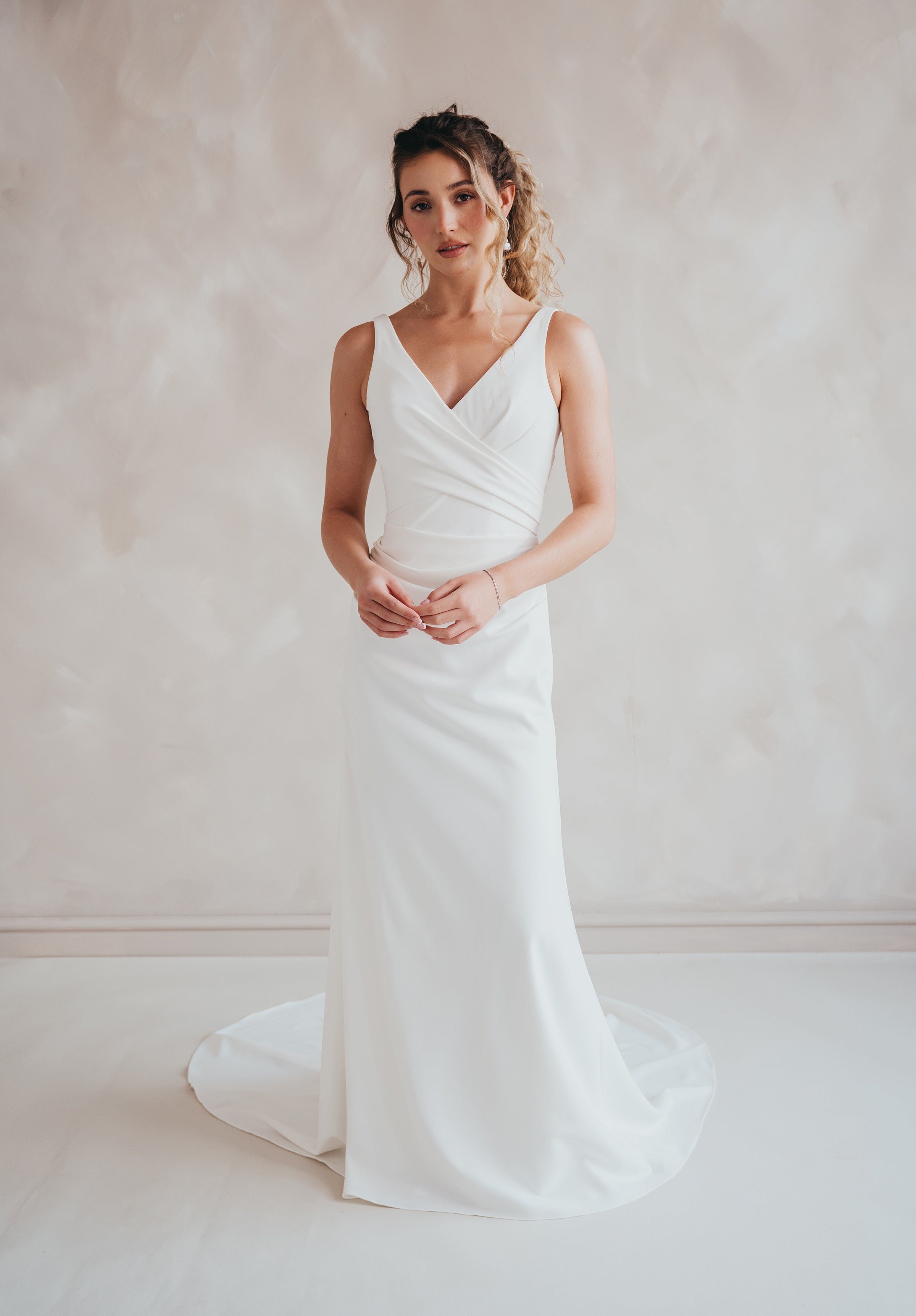 Bride wearing the Clover V-neck stretch crepe wedding dress with pleated bodice.