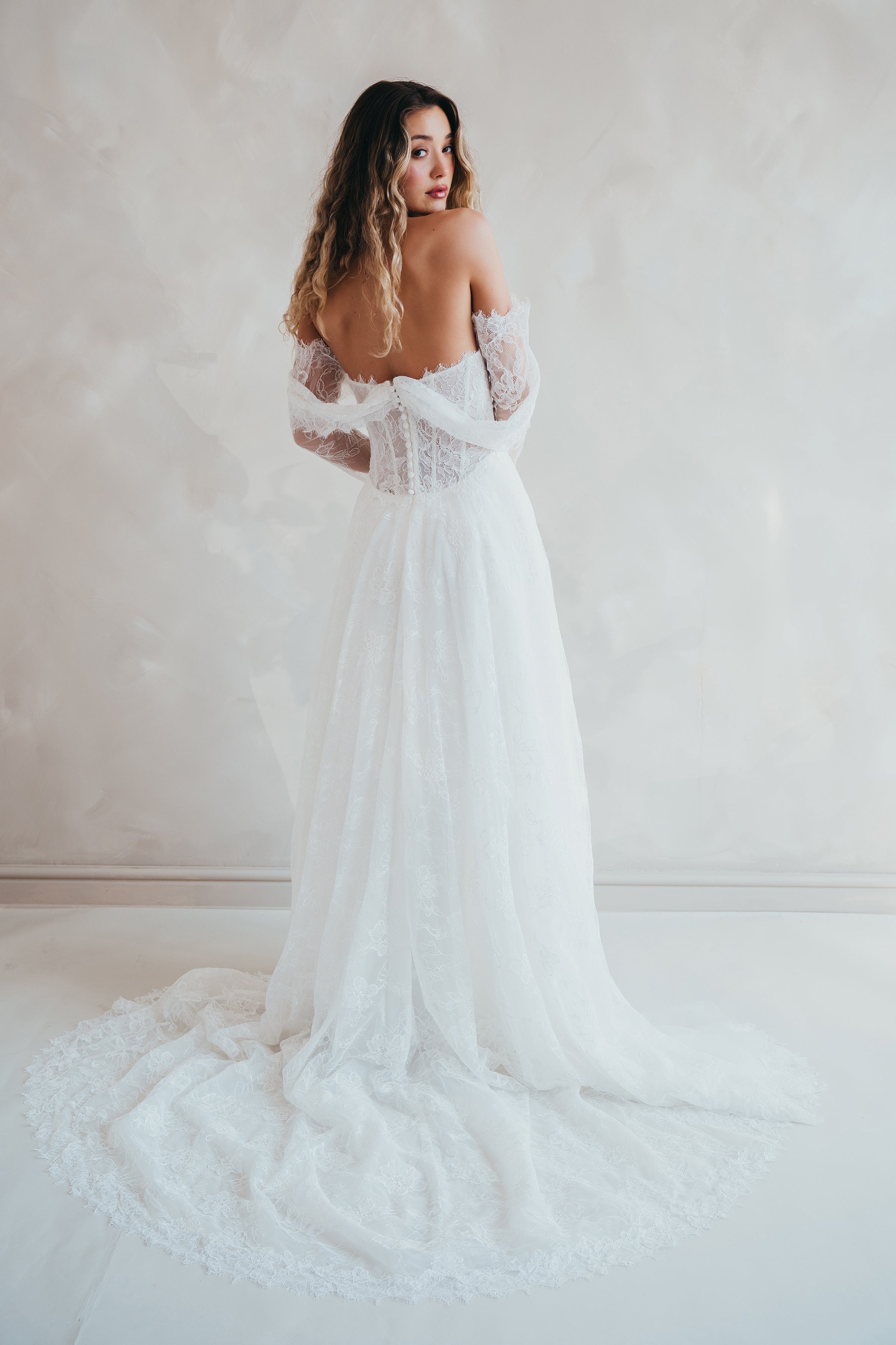 Bride wearing the Delilah lace wedding dress with dropped waist and layered A-line skirt.