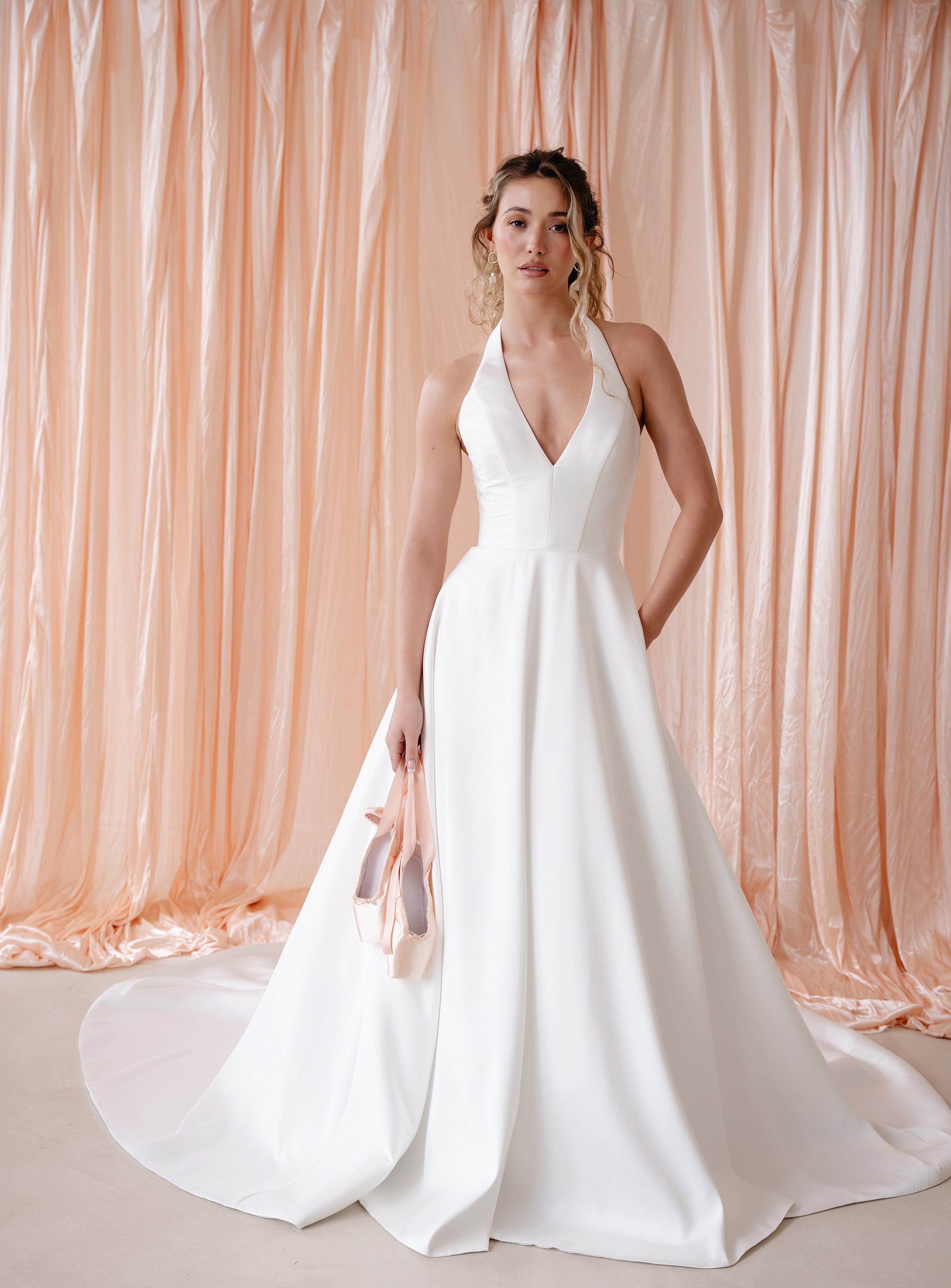 Bride wearing the Opal Mikado wedding dress with plunge halter neckline and A-line skirt.
