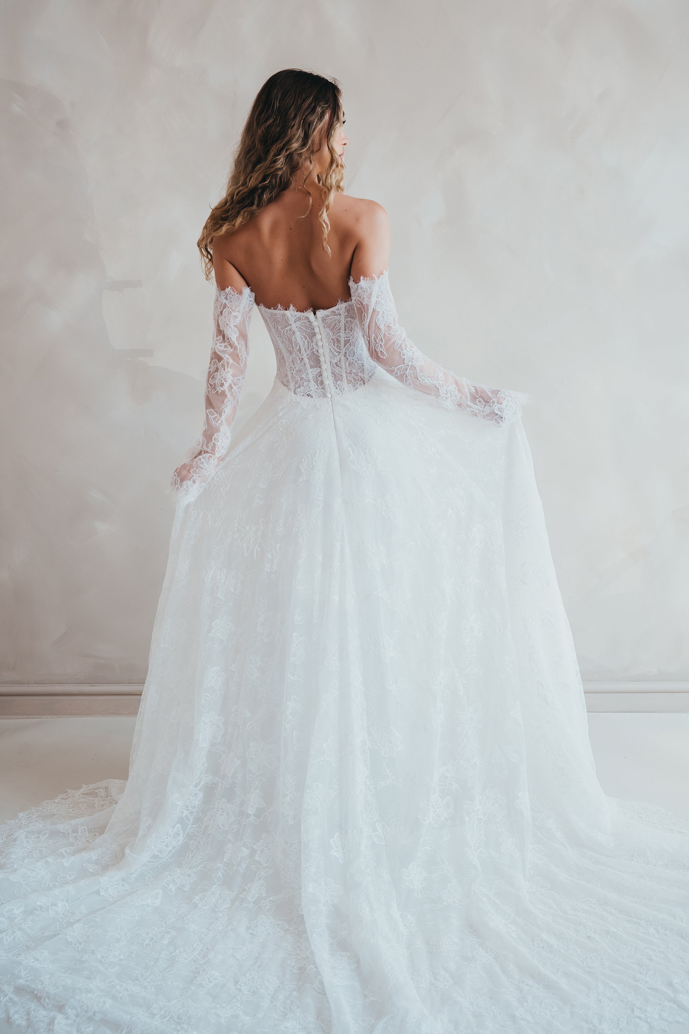 Bride wearing the Delilah lace wedding dress with dropped waist and layered A-line skirt.