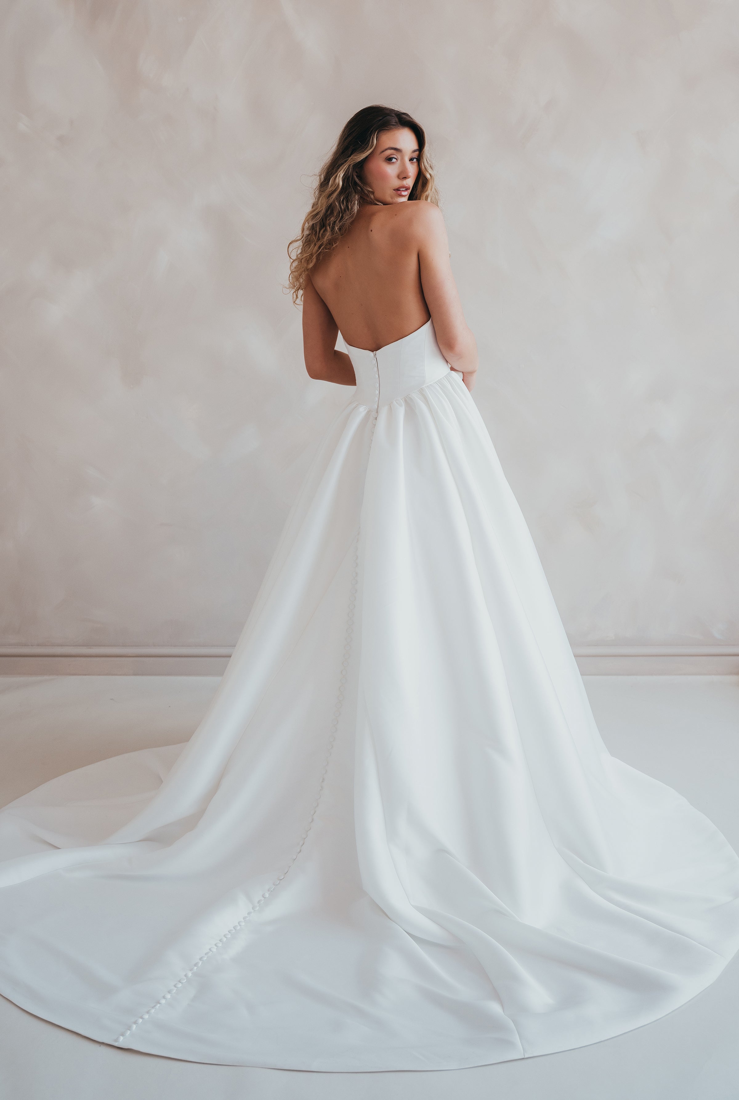 Bride wearing the Lua strapless Mikado wedding dress with pleated A-line skirt.