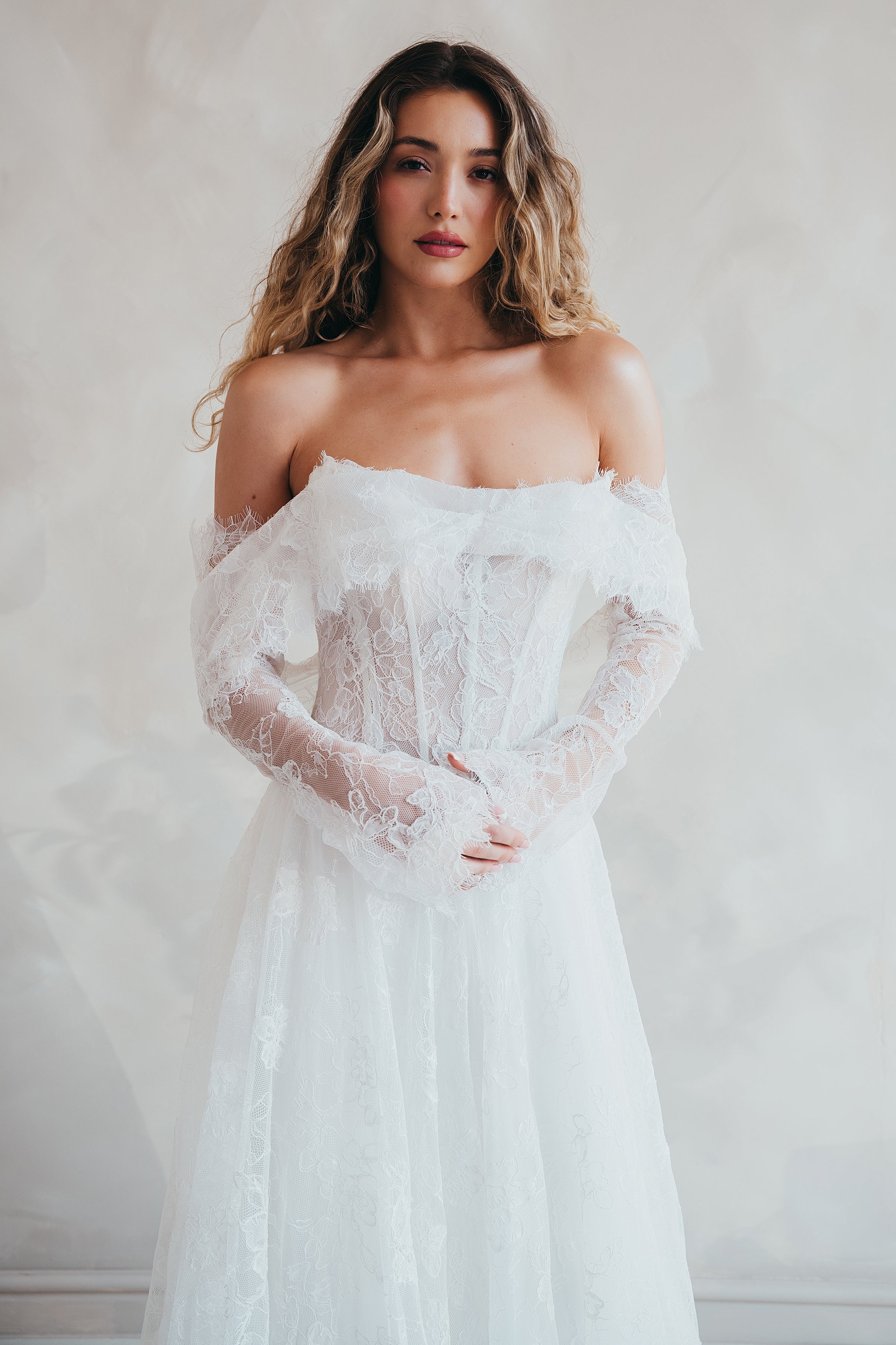 Bride wearing the Delilah lace wedding dress with dropped waist and layered A-line skirt with lace bolero.