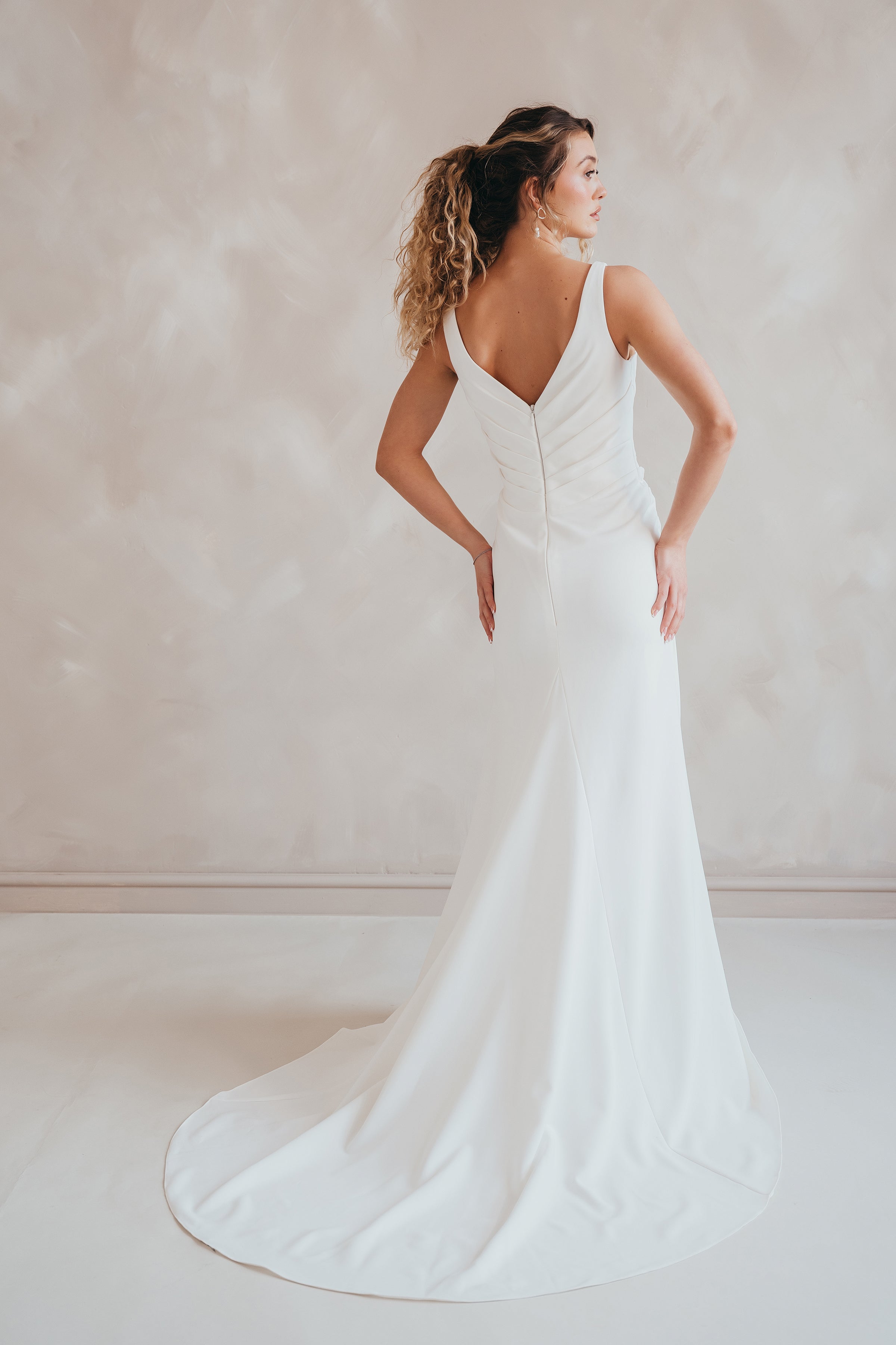 Bride wearing the Clover V-neck stretch crepe wedding dress with pleated bodice.