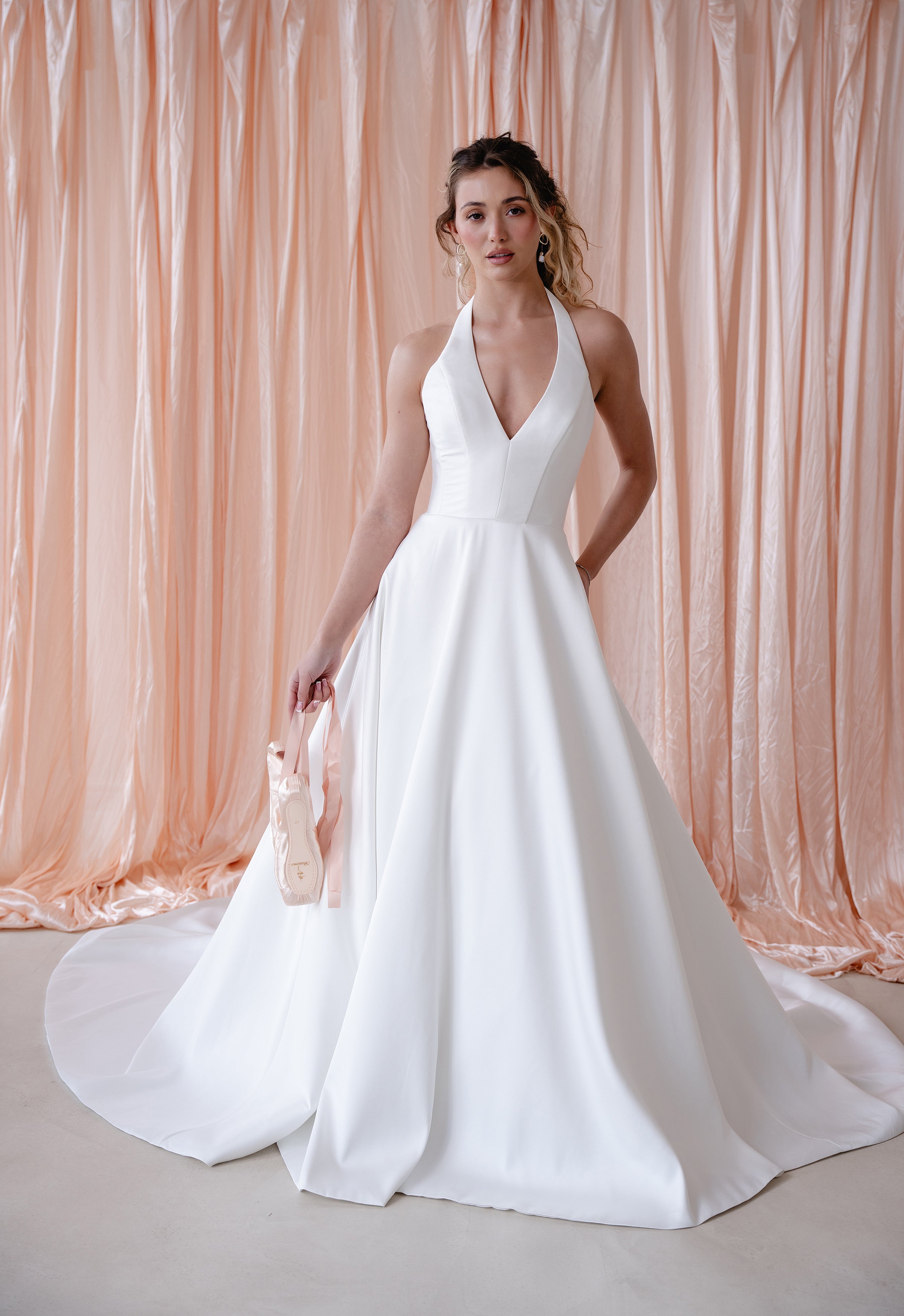 Bride wearing the Opal Mikado wedding dress with plunge halter neckline and A-line skirt.