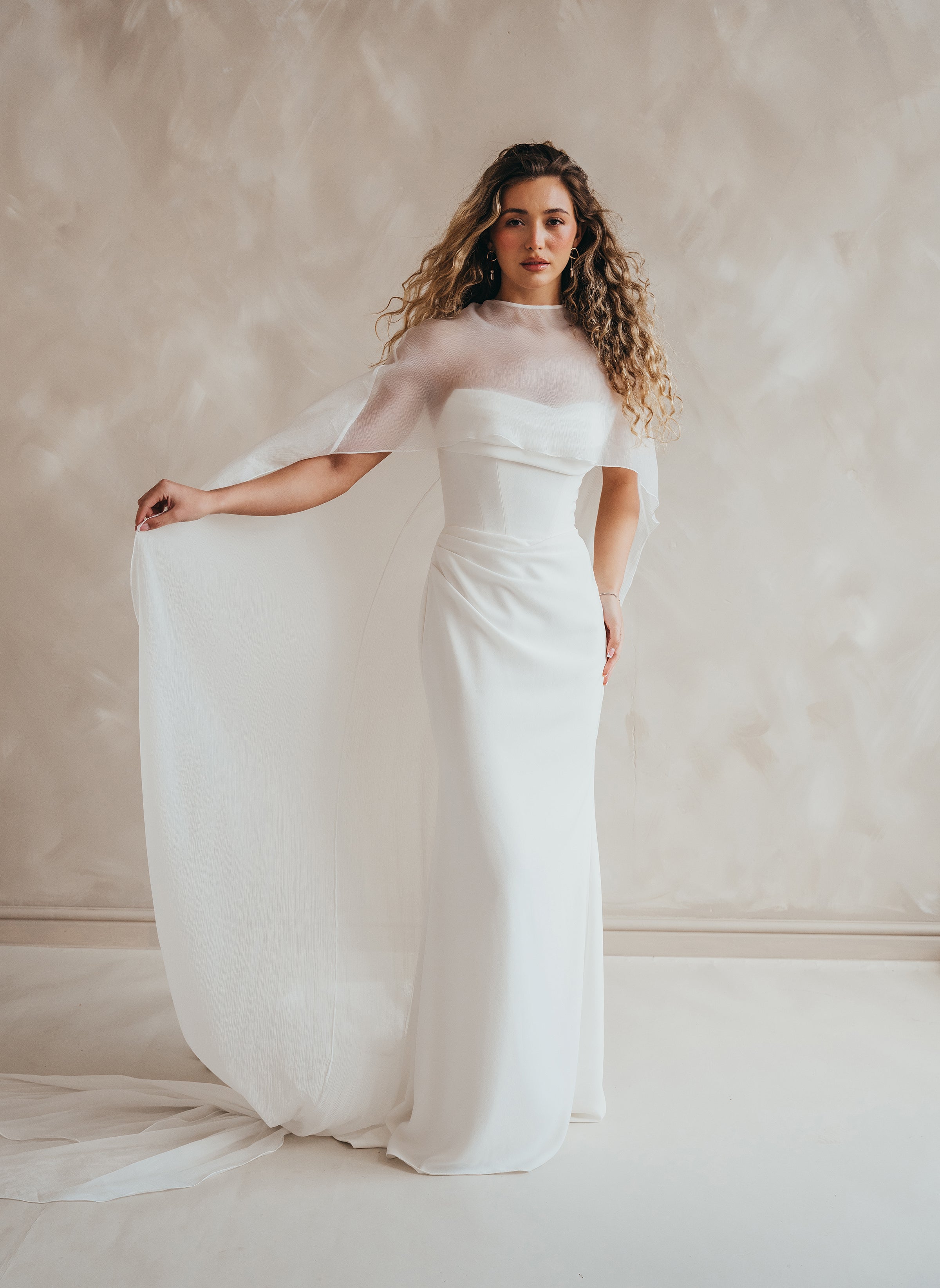 Bride wearing the Roxie chiffon bridal cape with flowing fabric and soft movement.