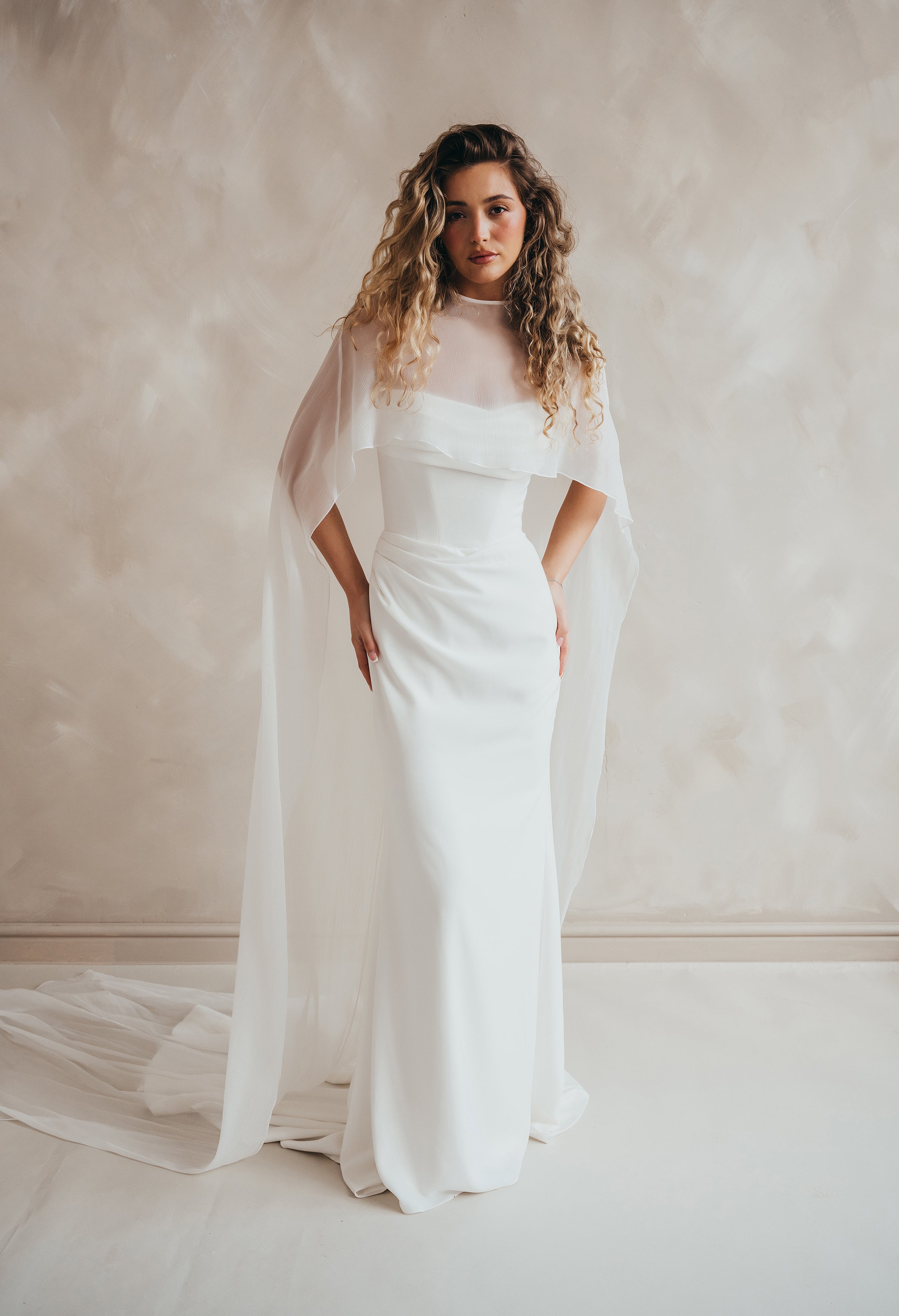 Bride wearing the Roxie chiffon bridal cape with flowing fabric and soft movement.
