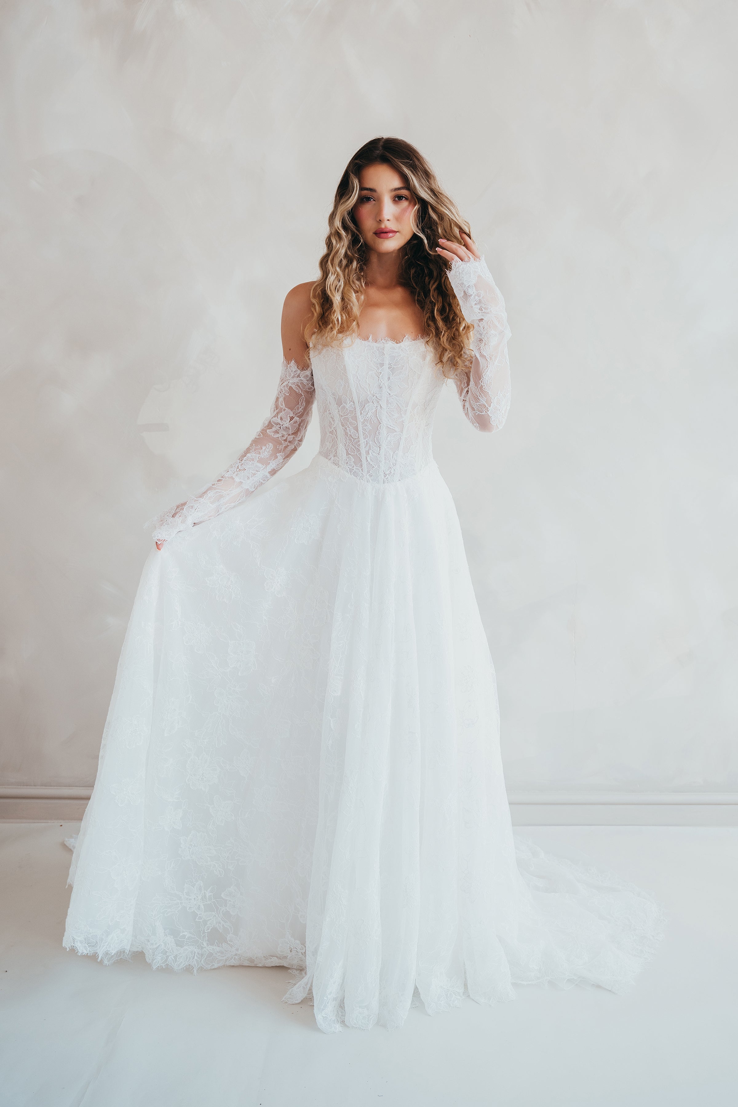 Bride wearing the Delilah lace wedding dress with dropped waist and layered A-line skirt.
