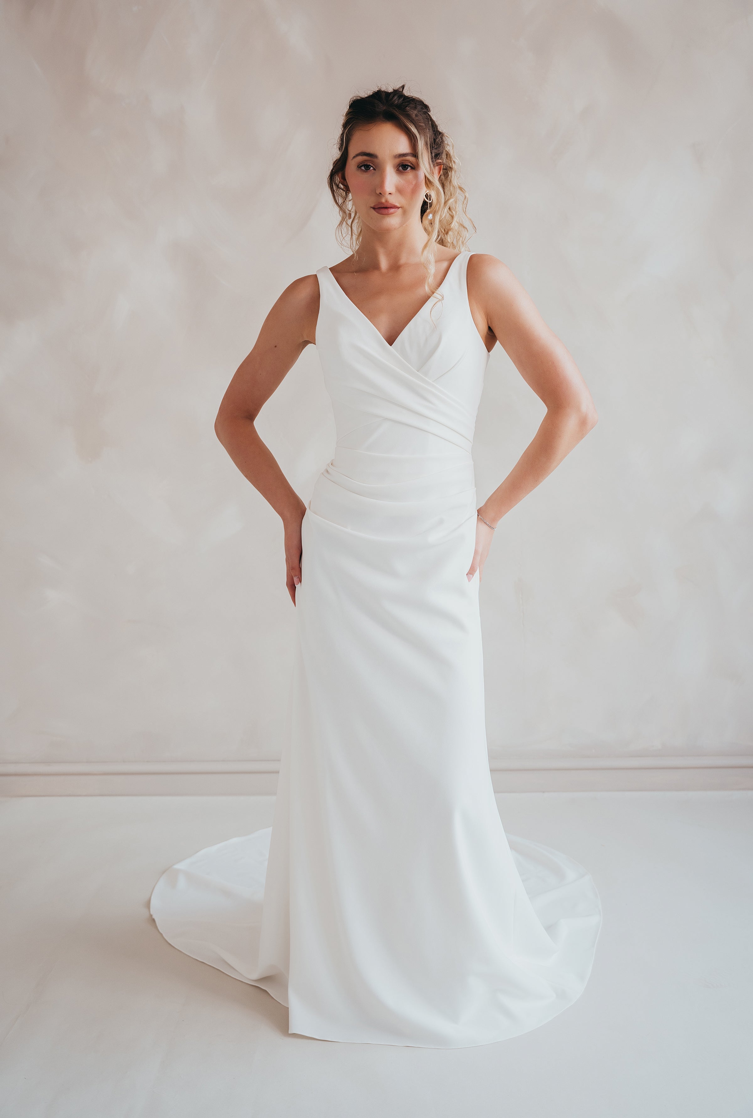 Bride wearing the Clover V-neck stretch crepe wedding dress with pleated bodice.