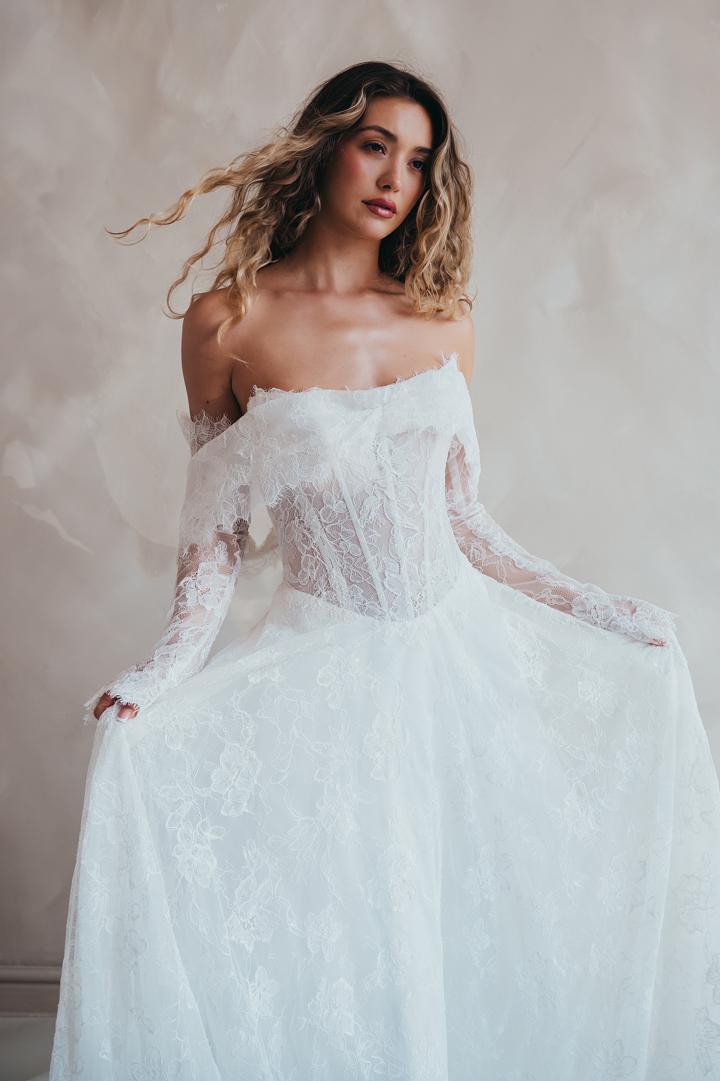 Bride wearing the Delilah lace wedding dress with dropped waist and layered A-line skirt with lace bolero.