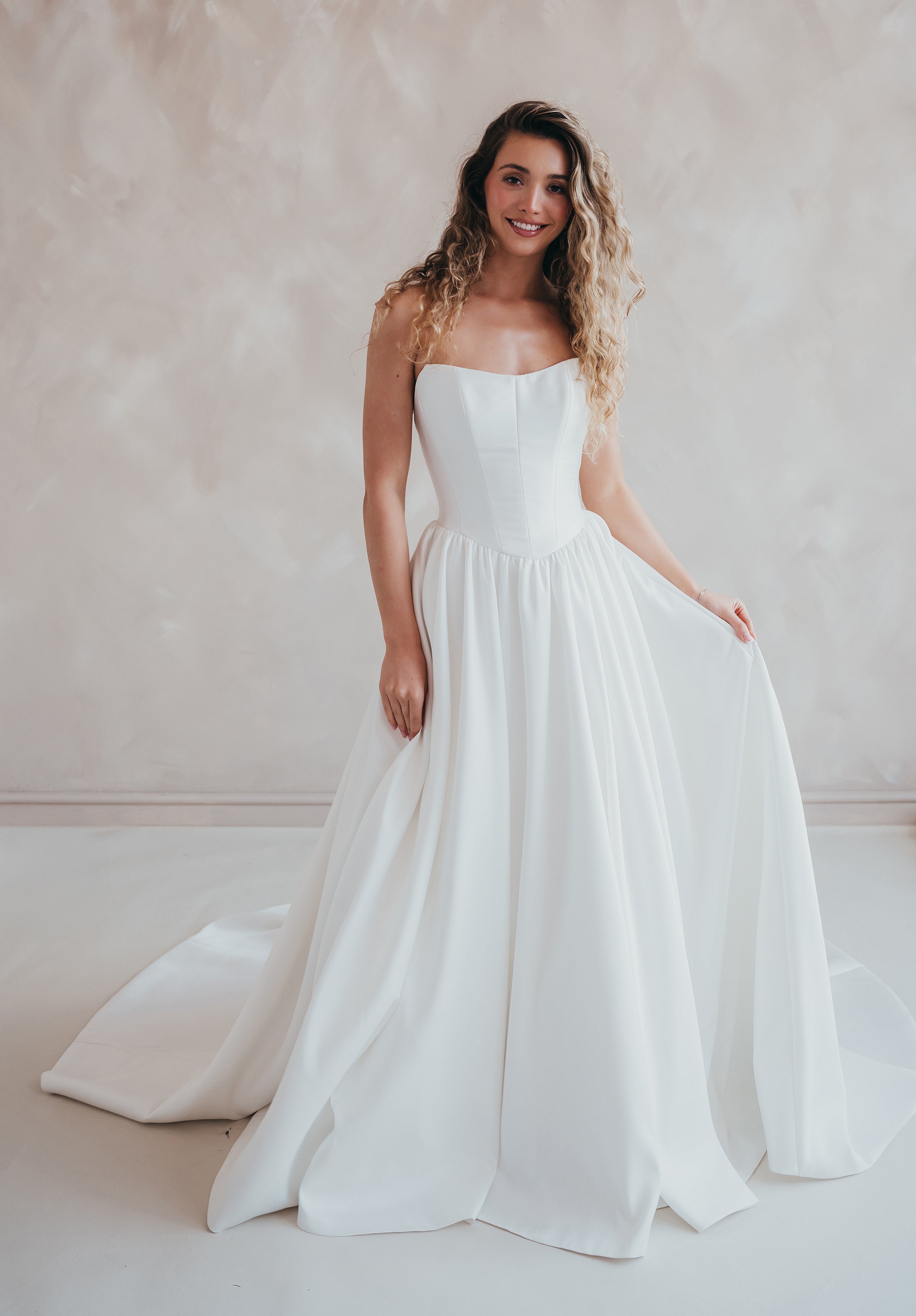 Bride wearing the Lua strapless Mikado wedding dress with pleated A-line skirt.