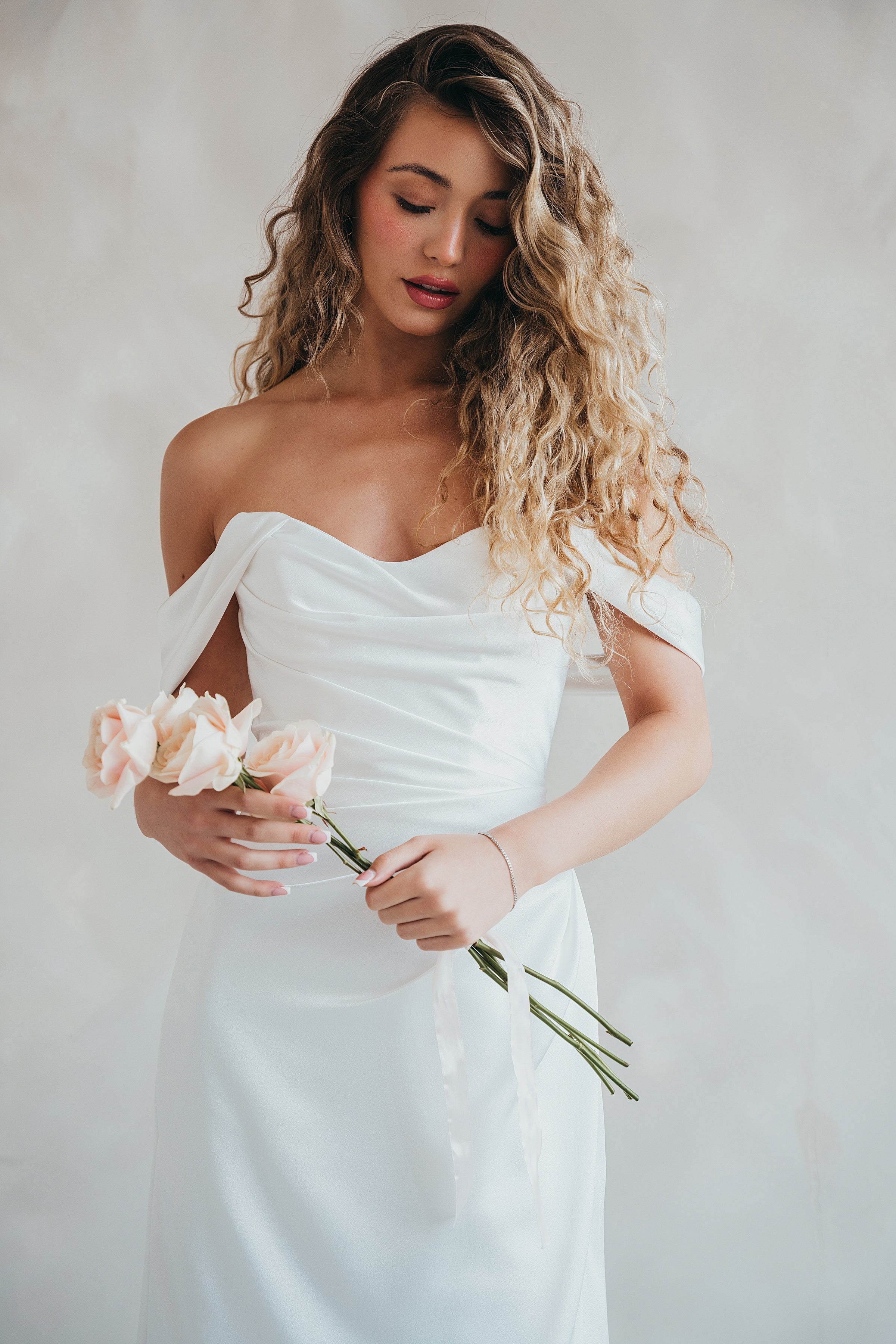 Bride wearing the Pearl satin wedding dress with sweetheart neckline and bardot sleeves.