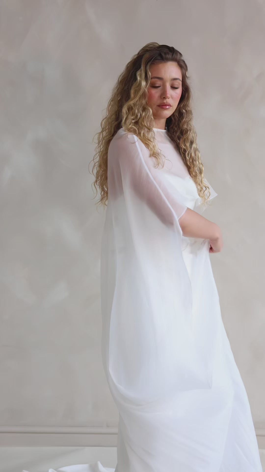 Bride wearing the Roxie chiffon bridal cape with flowing fabric and soft movement.