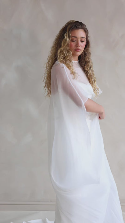 Bride wearing the Roxie chiffon bridal cape with flowing fabric and soft movement.