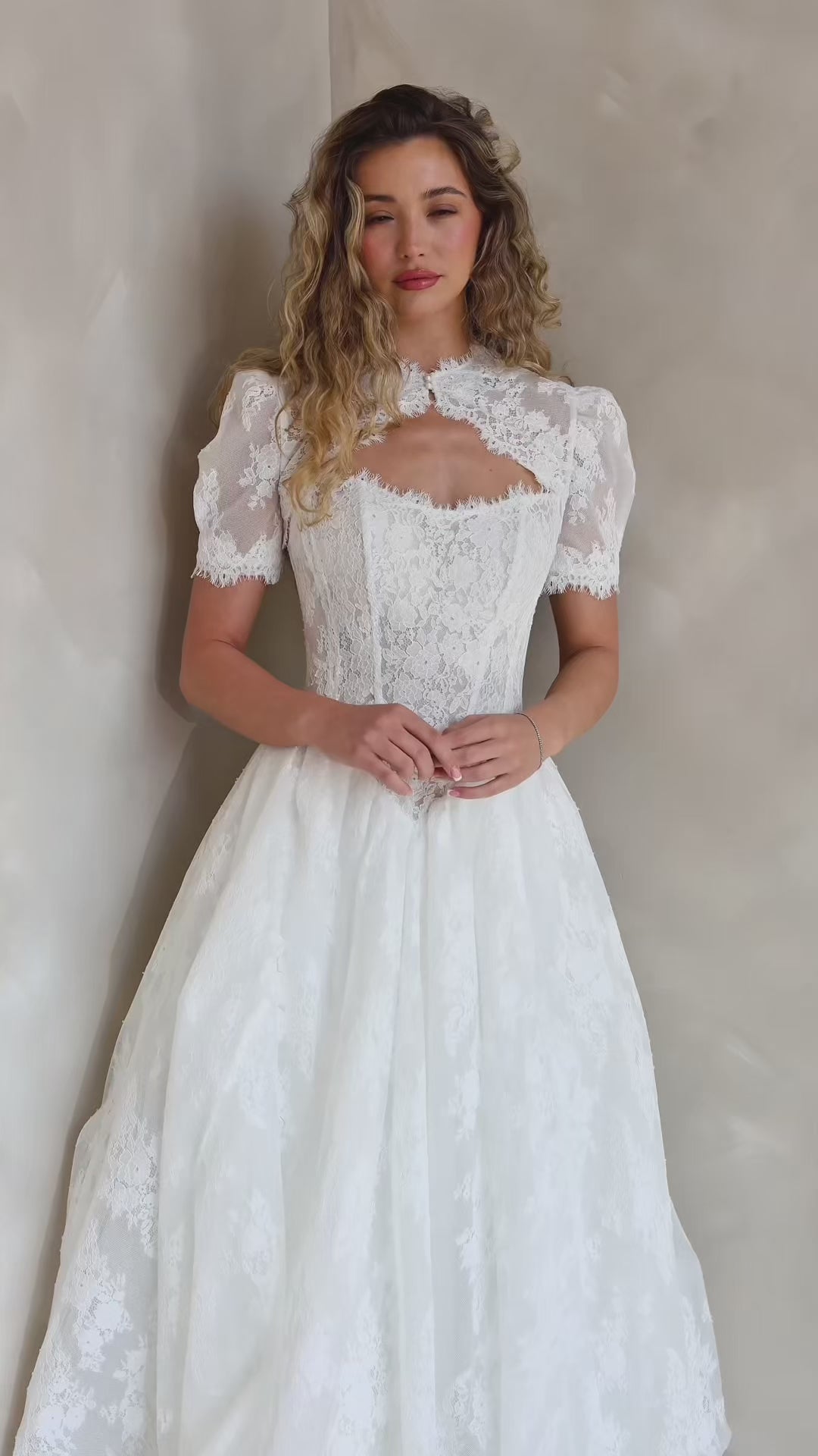 Bride wearing the Noemie Chantilly lace topper with puff sleeves and decorative lace trim.