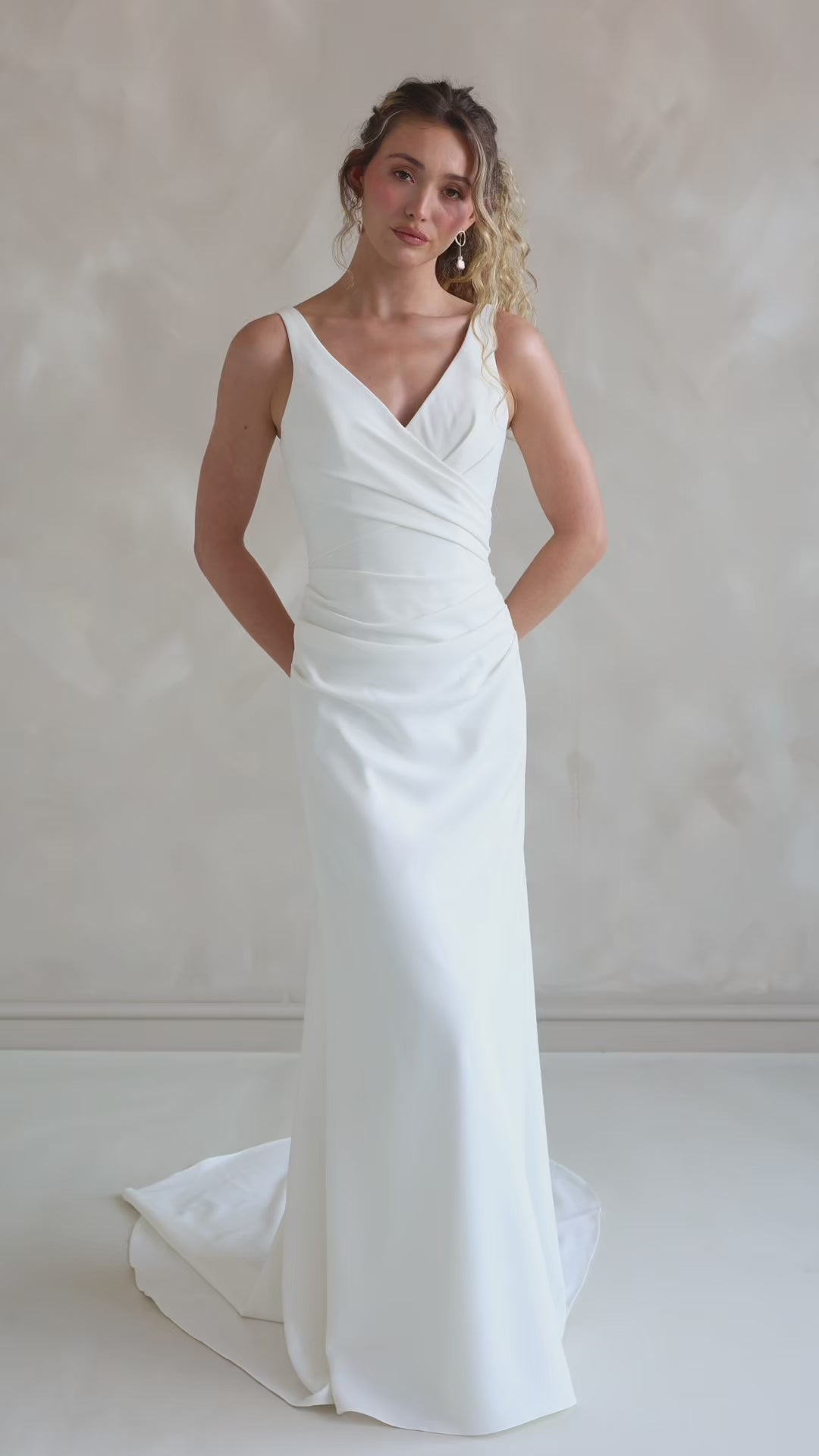 Bride wearing the Clover V-neck stretch crepe wedding dress with pleated bodice.