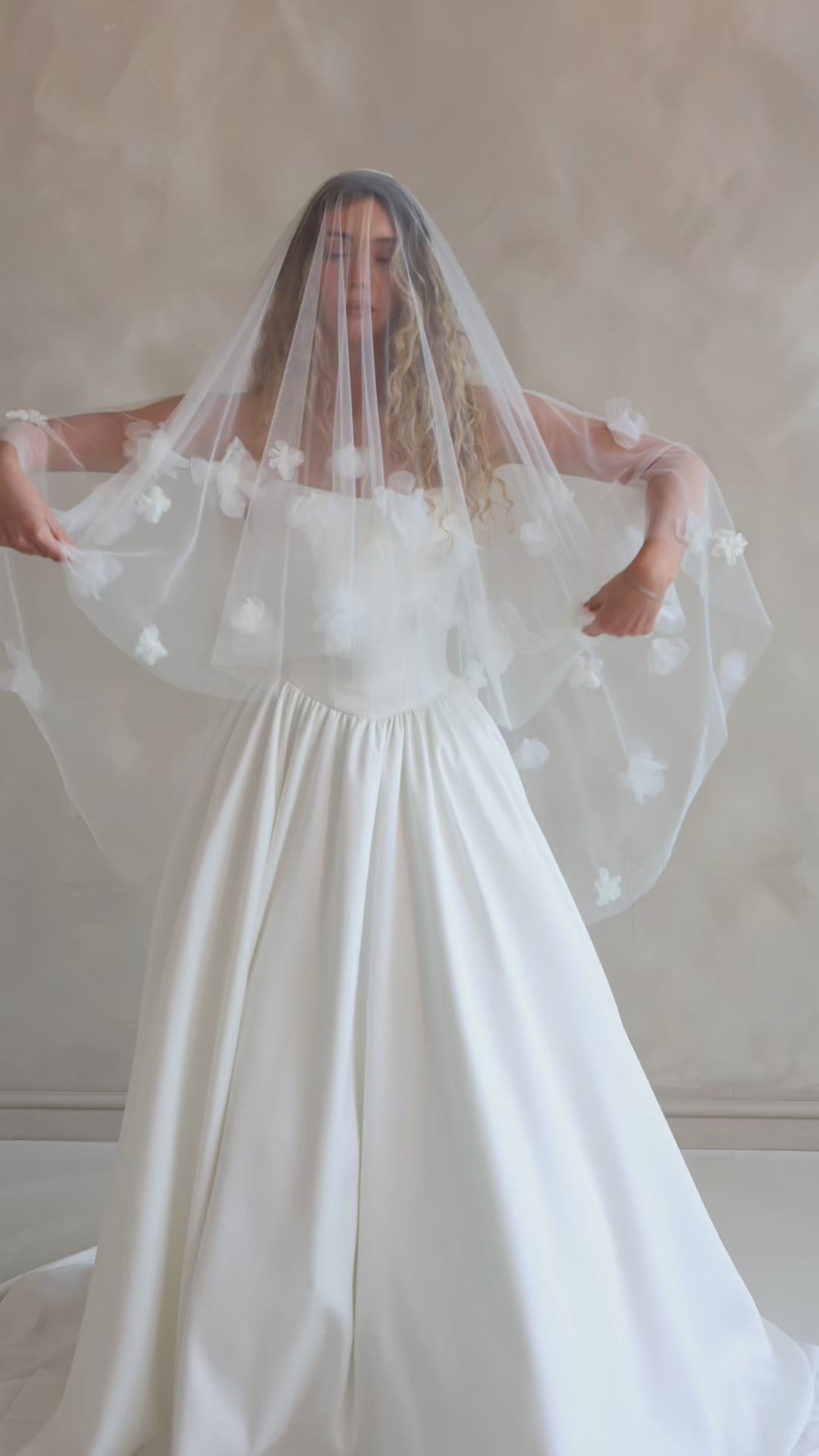 Bride wearing the Luz Shortie veil with floral detailing and blusher.