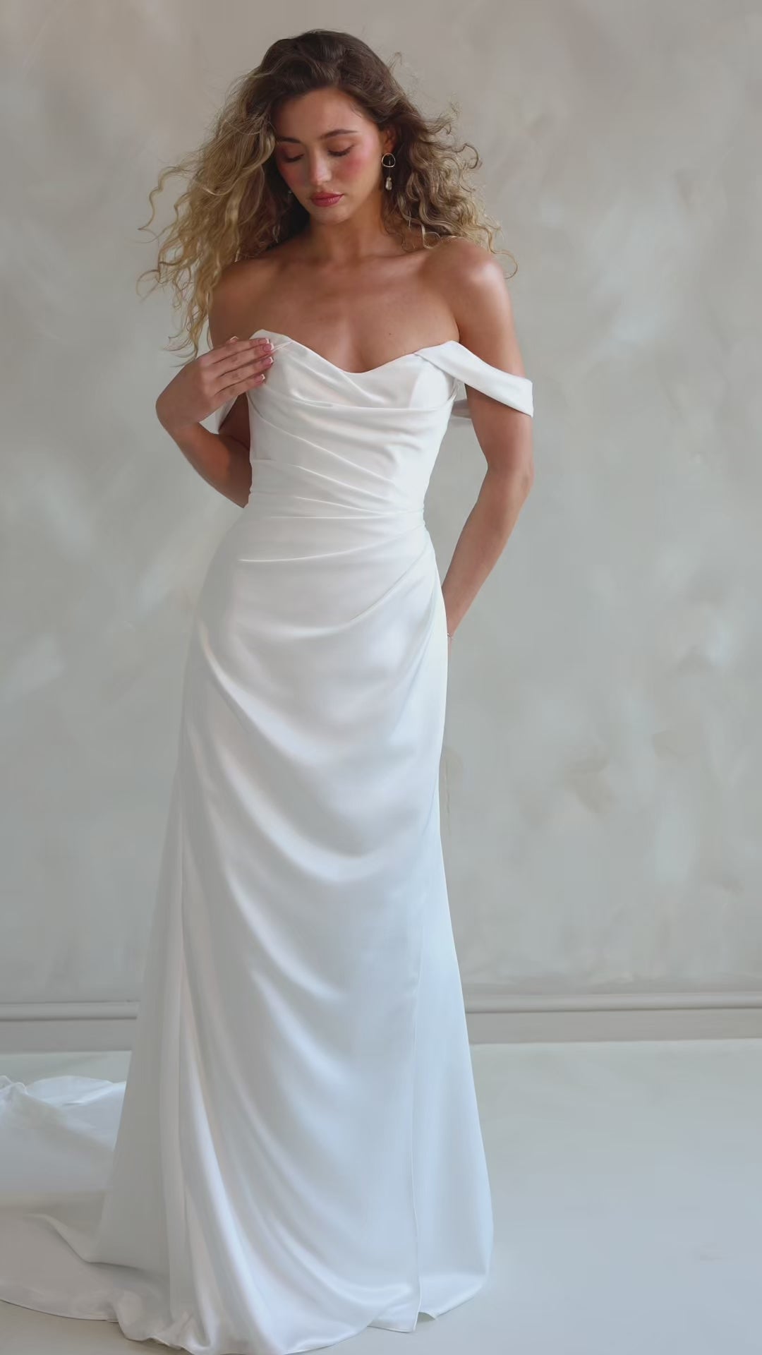 Bride wearing the Pearl satin wedding dress with sweetheart neckline and bardot sleeves.