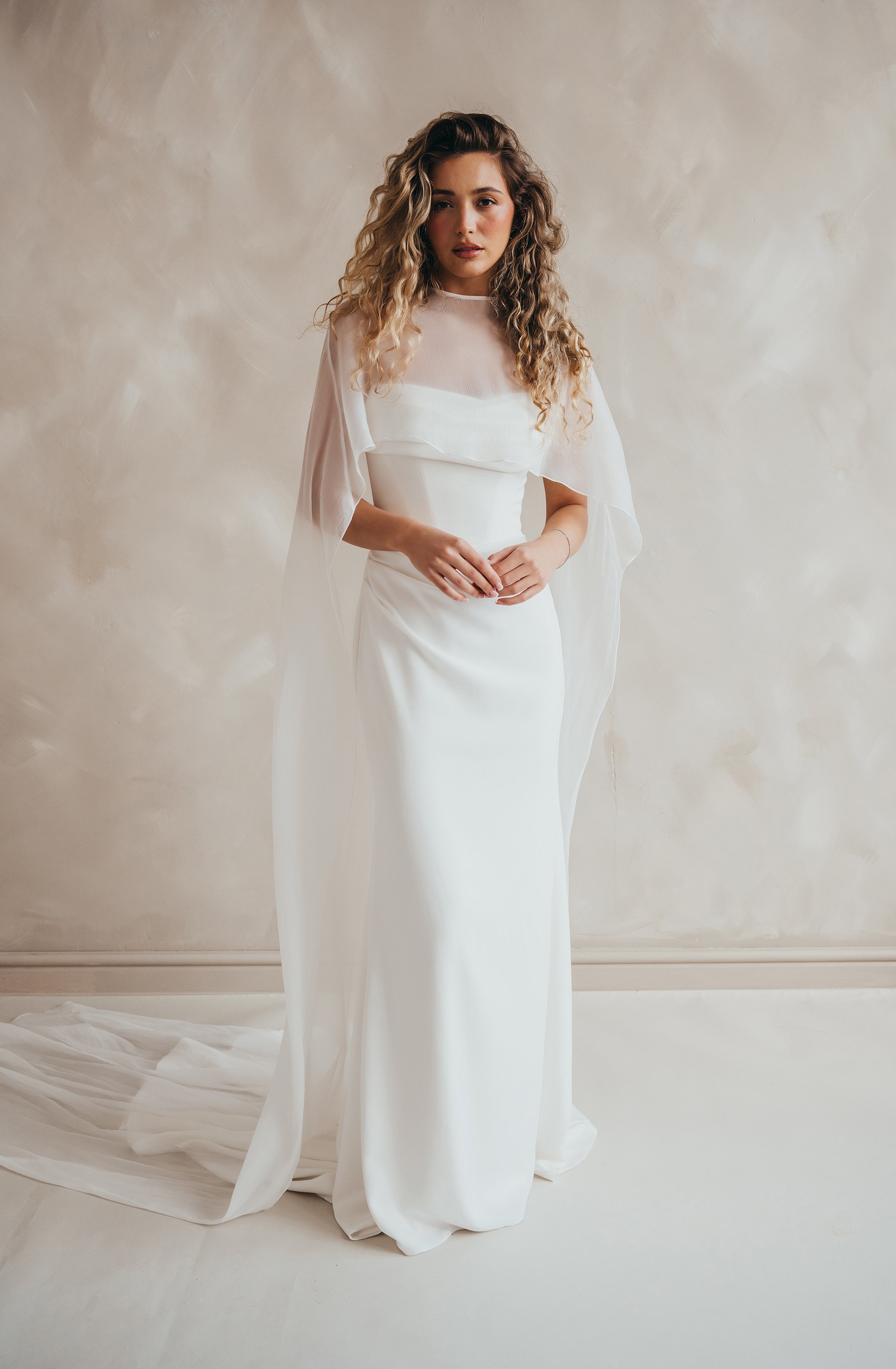 Bride wearing the Roxie chiffon bridal cape with flowing fabric and soft movement.