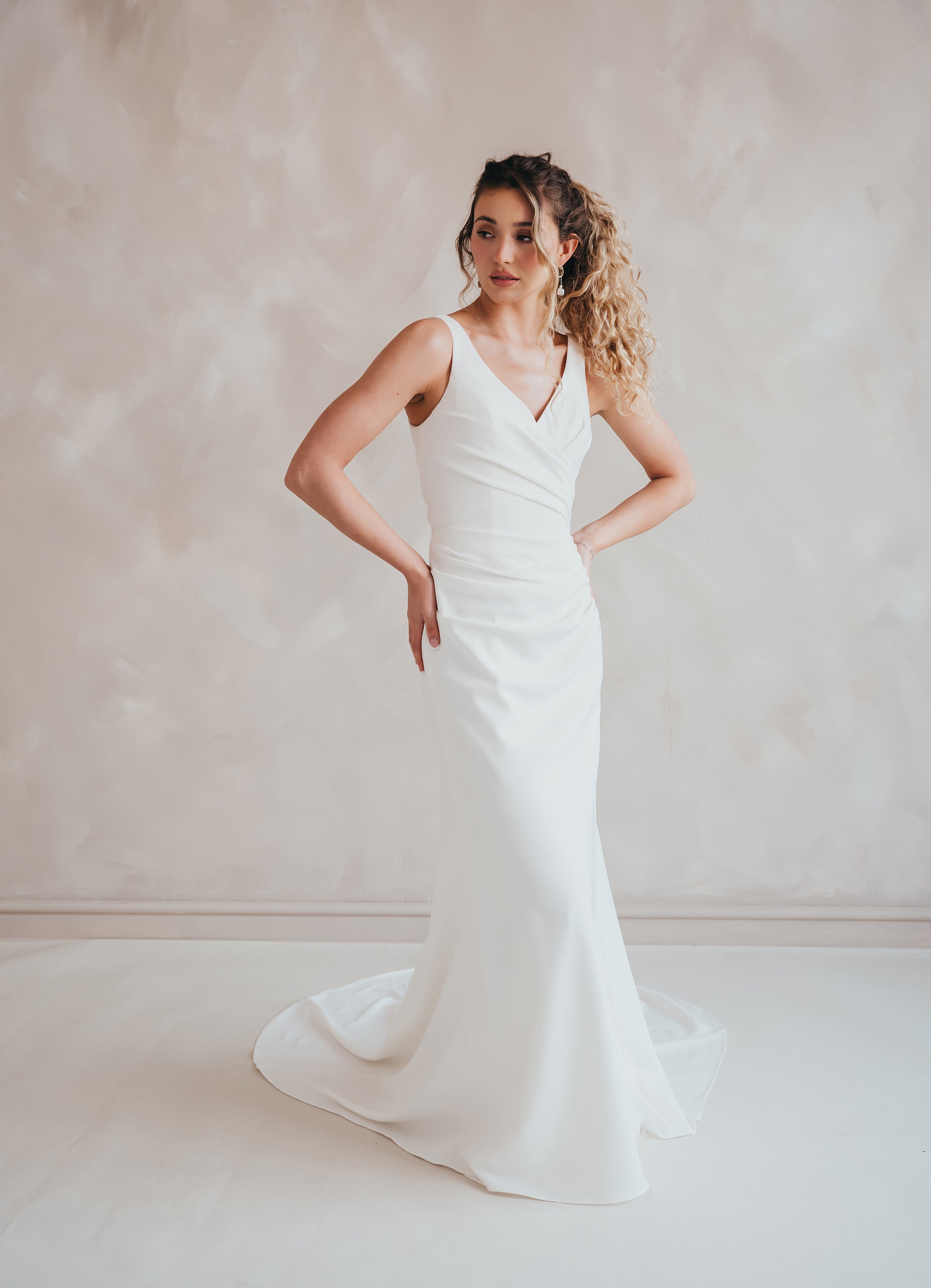 Bride wearing the Clover V-neck stretch crepe wedding dress with pleated bodice.
